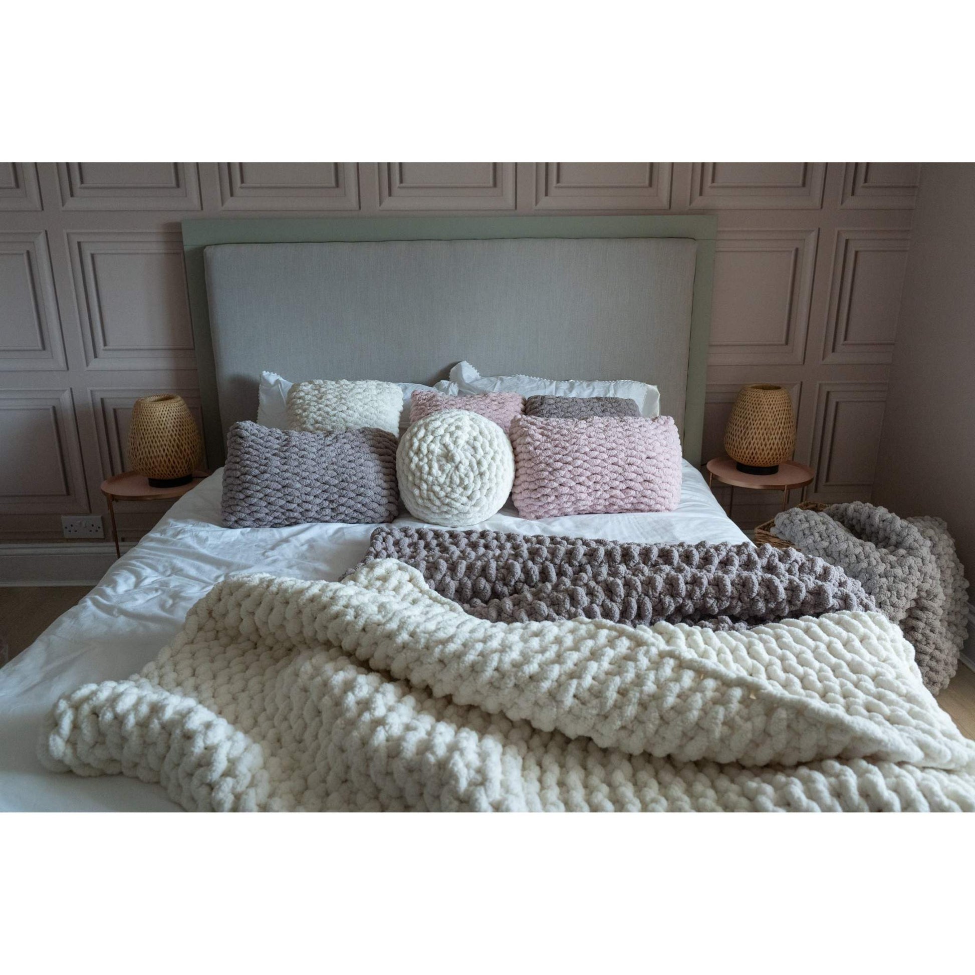 hand knit rectangular cushions and hand knit blankets on bed
